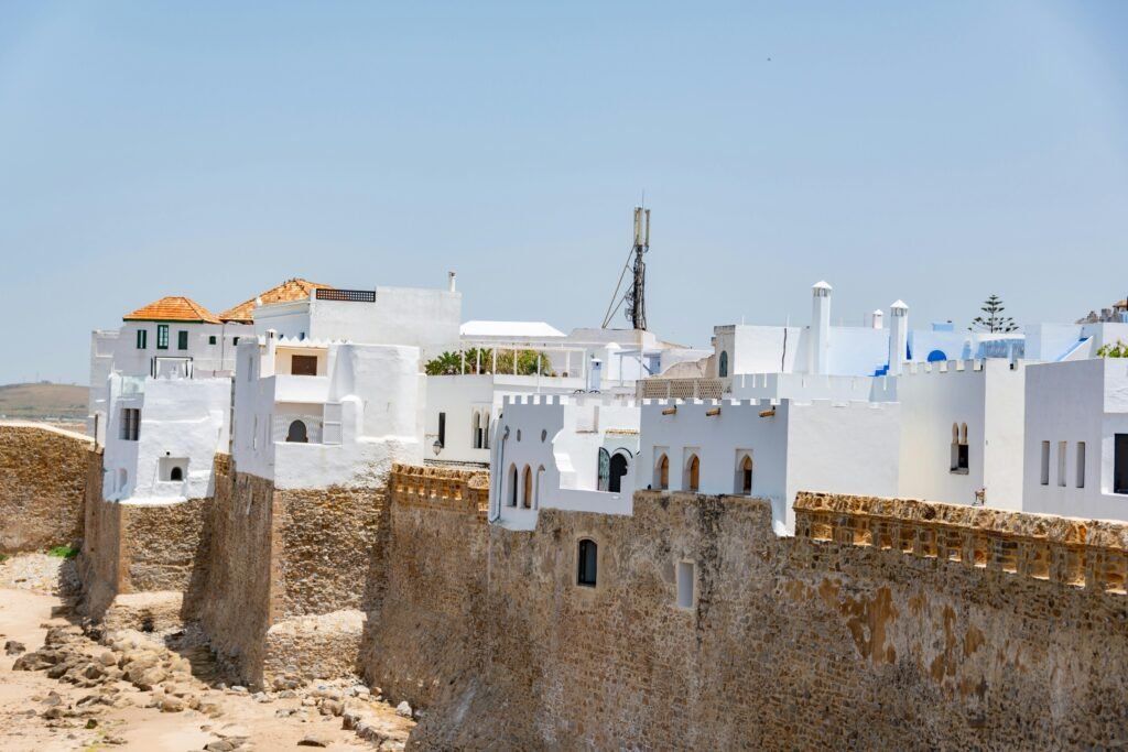 Charming white and blue architecture in the coastal town of Asilah under a clear sky.