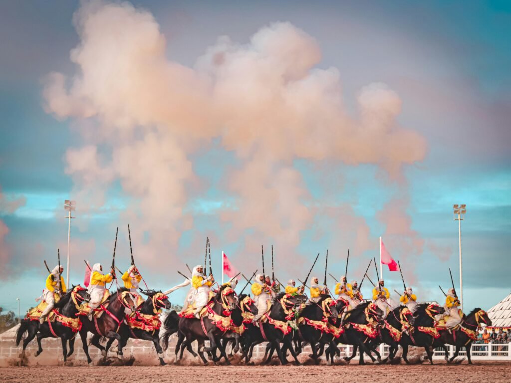 Traditional Fantasia horsemen in colorful attire performing in El Jadida, Morocco.