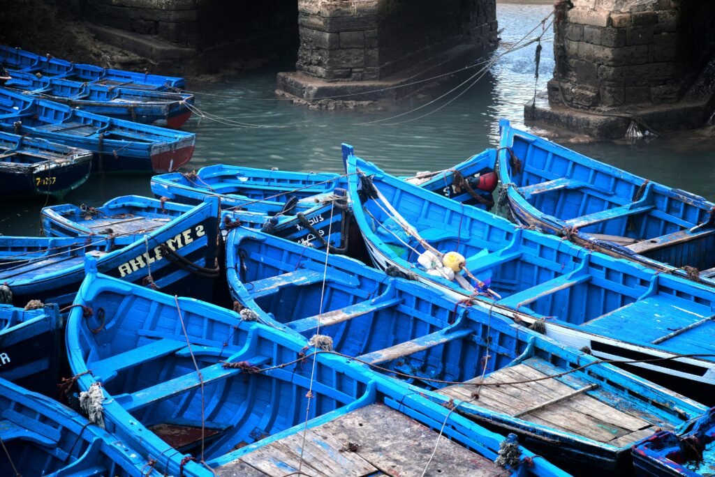 Vibrant blue fishing boats docked at Essaouira harbor, Morocco.